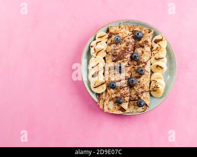 Crêpes avec tartinade aux noix de chocolat, banane, baies Banque D'Images