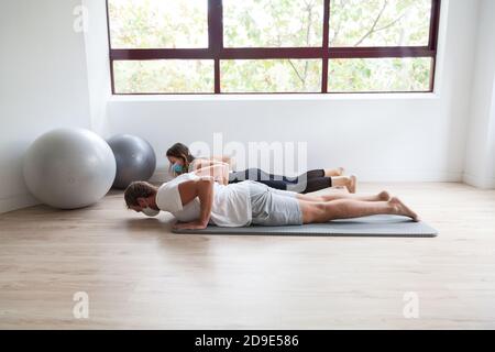 Un couple pratiquant le yoga en portant un masque de protection Banque D'Images