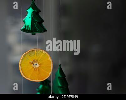 Décorations de Noël. Décoration orange et arbres de Noël verts en verre. Artisanat parfumé pour les vacances. Espace de copie pour le texte sur un arrière-plan sombre. Banque D'Images