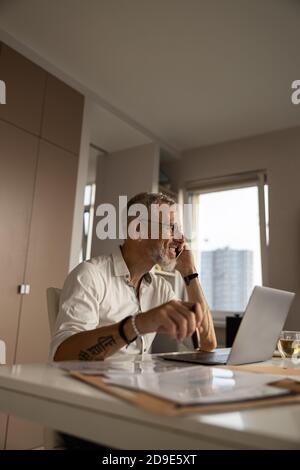 Homme ayant une discussion sur le téléphone portable dans son étude Banque D'Images