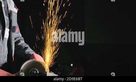 Atelier de forge. Smithy production manuelle. Close up détails de sparks, travailleur industriel, à l'aide d'angle meuleuse et couper l'acier. Banque D'Images