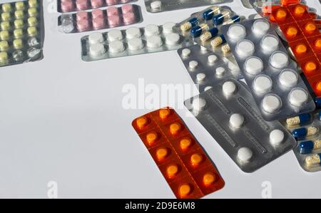 Les cloques avec des pilules se trouvent dans une pile sur un fond blanc. Copier l'espace pour le texte. Banque D'Images