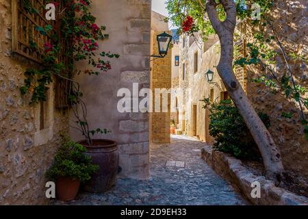 Architecture traditionnelle avec une petite rue en pierre et un bougainvilliers coloré dans le château médiéval de Monemvasia, Lakonia, Péloponnèse, Grèce Banque D'Images