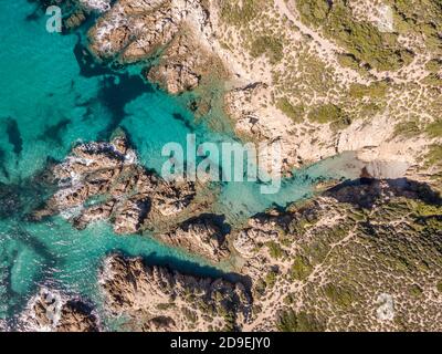 Vue aérienne sur une petite plage de sable et la Méditerranée turquoise Dans une crique rocheuse isolée près d'Ostriconi dans la Balagne Région de Corse Banque D'Images