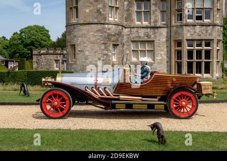 Une réplique pleine grandeur de la célèbre voiture volante Chitty Chitty Bang du film du même nom étant conduit par un membre du personnel en costume d'époque devant le Palace House, autrefois le portier de l'abbaye médiévale de Beaulieu, Est la maison familiale Montagu depuis 1538 et fait maintenant partie de l'attraction touristique centrée à haute voix le Musée national de l'automobile dans le village de Beaulieu dans la New Forest, Hampshire. 01 juin 2019. Photo: Neil Turner Banque D'Images