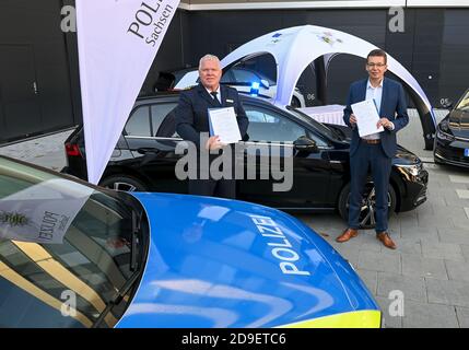 05 novembre 2020, Saxe, Zwickau: Horst Kretzschmar (l.), Président de la police d'Etat en Saxe et Reinhard de Vries, Directeur général technologie et logistique de Volkswagen Saxe, se tiennent devant un véhicule de police spécial VW Golf avec un accord de coopération. Volkswagen Sachsen et la police saxonne ont signé un accord de coopération sur la coopération future. À l'avenir, la police sera en mesure de tester intensivement dans la pratique les générations actuelles de véhicules VW. En retour, le constructeur automobile recevra des conclusions sur le développement de véhicules de police spéciaux. Le projet commence par deux civils Banque D'Images
