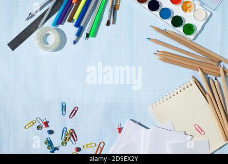 Cadre pour texte avec fournitures scolaires. Peintures stylos crayons pinceaux compas papier papier écriture trombones scotch ruban boutons papeterie règle feutre-pointe Banque D'Images