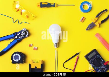 Jeu d'outils d'électricien sur fond jaune. Composition de pose à plat avec outils d'électricien et espace pour le texte fond jaune Banque D'Images