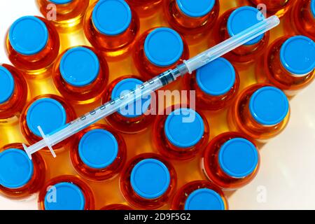 Flacons et seringue de vaccin sur fond blanc Banque D'Images