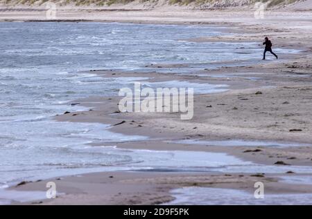 Lubmin, Allemagne. 05ème novembre 2020. Une femme marche à travers la plage presque vide de la mer Baltique. En tant que mesure de protection de la couronne, les touristes doivent quitter le Mecklembourg-Poméranie occidentale d'aujourd'hui au plus tard. Un verrouillage partiel de quatre semaines a commencé dans toute l'Allemagne sur 02.11.2020 pour ralentir la propagation du virus corona. Credit: Jens Büttner/dpa-Zentralbild/dpa/Alay Live News Banque D'Images