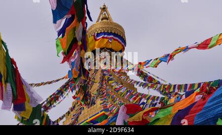 Vue rapprochée du haut populaire Boudhanath stupa (Boudha) dans le centre de Katmandou, Népal avec des drapeaux de prière colorés volant dans le vent. Banque D'Images