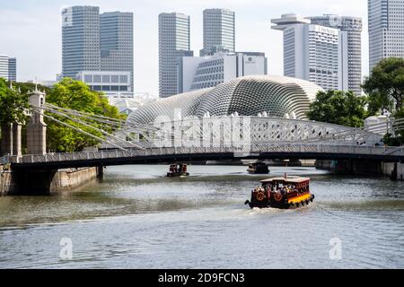 Singapour, 21/01/19. Cavenagh Bridge, seul pont suspendu et l'un des plus anciens de Singapour, avec des bateaux touristiques et la ligne d'horizon de Singapour. Banque D'Images