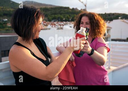 Deux femmes entrent en collision avec leurs bouteilles d'eau réutilisables après un sport Session.Sport concept Banque D'Images