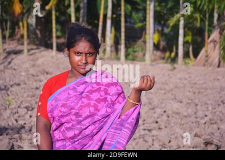Gros plan d'une adolescente indienne portant une robe traditionnelle sari avec de longs poils debout sur un terrain, concentration sélective Banque D'Images