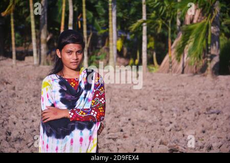 Gros plan d'une adolescente indienne portant une robe traditionnelle avec de longs poils debout sur un terrain, concentration sélective Banque D'Images