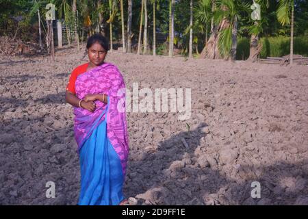 Une adolescente indienne portant une robe traditionnelle sari avec de longs poils debout sur un champ, concentration sélective Banque D'Images