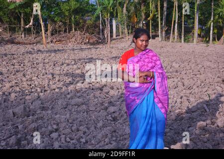 Une adolescente indienne portant une robe traditionnelle sari avec de longs poils debout sur un champ, concentration sélective Banque D'Images