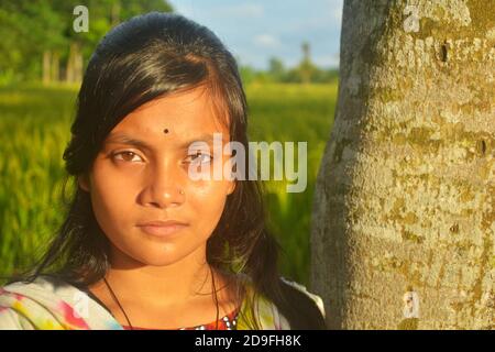 Gros plan d'une adolescente indienne portant une tige de nez bindi sur le front avec de longs poils foncés, mise au point sélective Banque D'Images