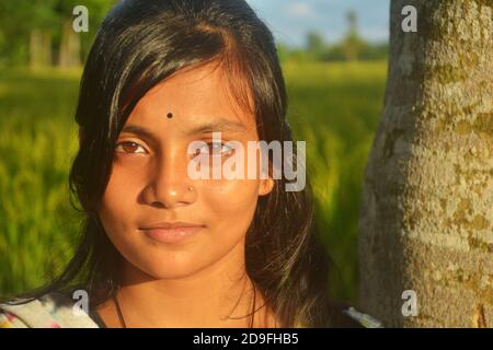 Gros plan d'une adolescente indienne portant une tige de nez bindi sur le front avec de longs poils foncés, mise au point sélective Banque D'Images