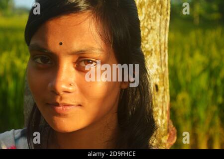 Gros plan d'une adolescente indienne portant une tige de nez bindi sur le front avec de longs poils foncés, mise au point sélective Banque D'Images