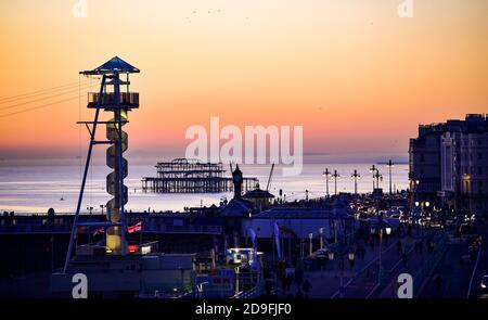 Brighton UK 5th novembre 2020 - le soleil se couche sur le front de mer de Brighton avec le câble Zip en premier plan et le West Pier ce soir comme le premier jour des nouvelles restrictions de verrouillage du coronavirus en Angleterre tire à sa fin : Credit Simon Dack / Alay Live News Banque D'Images