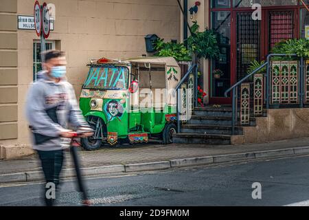 La vie quotidienne. Jeune homme sur un scooter portant un masque facial traversant la route. La jeunesse contre le vieux concept. Banque D'Images
