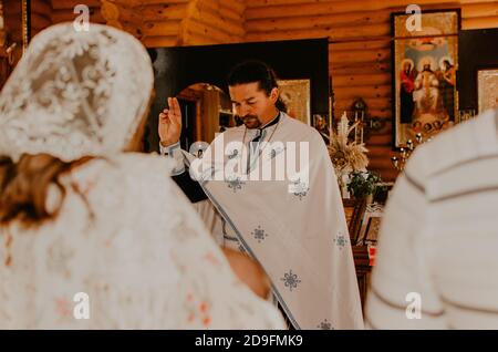 Letychiv, Ukraine - 10.15.2020: Le prêtre bénit les parrains et les baptise Banque D'Images