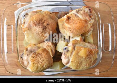 Vue en hauteur des cuisses de poulet cuites au four sur le dessus de rôti pommes de terre dans un plat de cocotte Banque D'Images