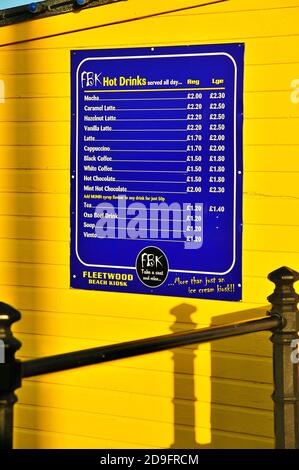 Menu bleu sur le mur jaune du kiosque Fleetwood Beach à coucher de soleil Banque D'Images