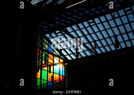 Une grande photographie du soleil de l'après-midi qui saule à travers le panneaux de vitraux du centre commercial local et création silhouettes au premier plan Banque D'Images