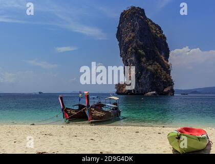 Krabi, Thaïlande- Mars 29 2019:bateau traditionnel à longue queue de bois dans l'eau tirquese bleu, et kayak vert dans le sable blanc de plage, visite des îles, énorme ba de roche Banque D'Images