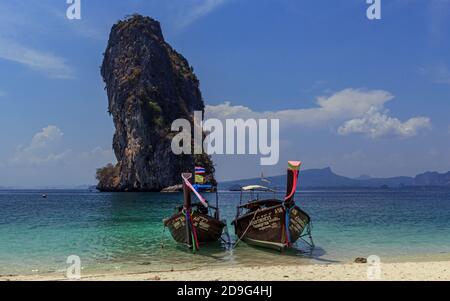 Krabi, Thaïlande- Mars 29 2019:bateau traditionnel à longue queue de bois dans l'eau tirquese bleu, visite des îles, fond de roche énorme Banque D'Images