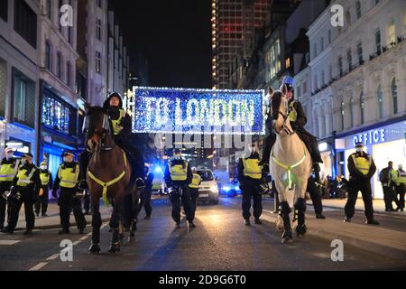 Des policiers lors de la manifestation anti-establishment du million Mask March à Trafalgar Square à Londres, le premier jour d'un confinement national de quatre semaines pour l'Angleterre. Banque D'Images