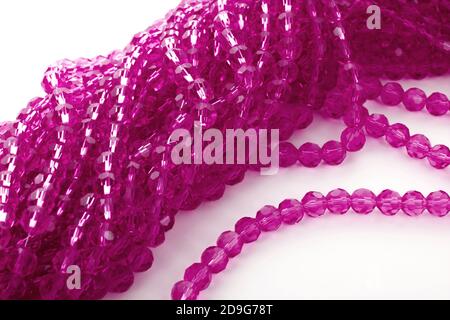 Magnifiques perles isolantes en verre rose étincelant sur fond blanc. À utiliser pour les bijoux à perles de bricolage. Espace pour le texte Banque D'Images