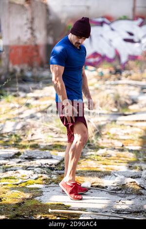 Portrait d'un jeune homme physiquement en forme debout dans l'entrepôt Montrant son corps bien formé Banque D'Images