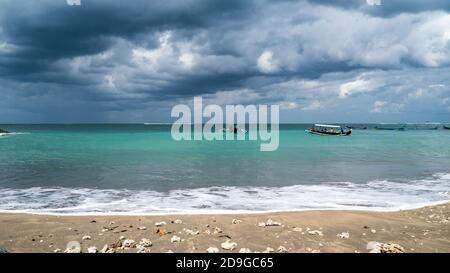 tempête sur la mer, bateau de pêche sur la plage. Avant la pluie en Indonésie, ciel nuageux et spectaculaire Banque D'Images