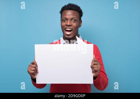 Beau homme d'affaires africain sérieux présentant un produit Banque D'Images