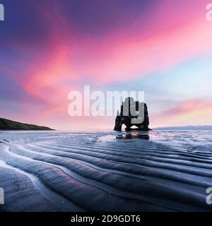 Basalte stack Hvitserkur sur la péninsule de Vatnsnes, Islande, Europe en temps de marée basse. Grand ciel violet brillant sur fond. Photographie de paysage Banque D'Images