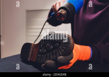 Cordonnier chauffant le fond de la chaussure qu il fait pour