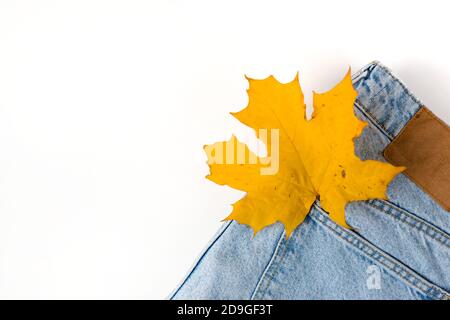 Gros plan sur la feuille d'érable dans la poche jean. Denim tendance en automne. Macro. Pose à plat. Vue de dessus. Banque D'Images