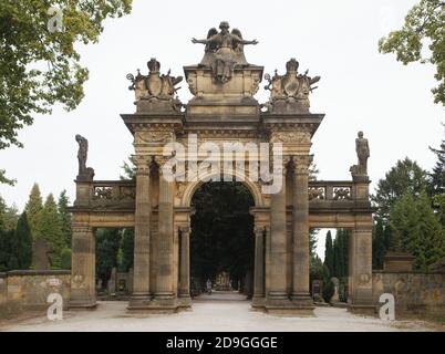 L'homme solitaire passe par la porte monumentale du nouveau cimetière (Nový hřbitov) de Hořice en Bohême de l'est, en République tchèque. La porte conçue par les sculpteurs tchèques Bohuslav Moravec a Antonín Cechner a été produite de 1893 à 1907 par des élèves de l'école de sculpture de Hořice. La statue de l'ange a été conçue par le sculpteur tchèque Mořic Černil et deux statues de la mort et de la Résurrection flanquées la porte a été conçue par le sculpteur tchèque Quido Kocián. Banque D'Images