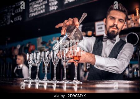 Le barman mélange un cocktail dans le portreuse Banque D'Images