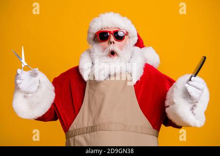 Portrait en gros plan d'un joli joli joli père Noël à poil gris port d'un tablier tenant dans les mains coiffure équipement salon de beauté isolé Banque D'Images