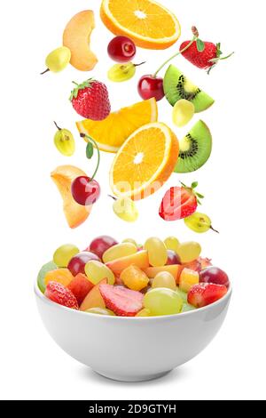 Salade de fruits délicieuse dans un bol et ingrédients frais sur du blanc arrière-plan Banque D'Images
