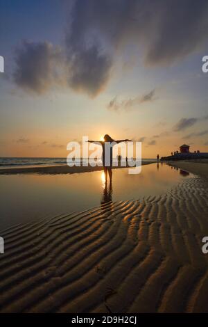 Silhouette de femme debout dans l'eau de plage Banque D'Images
