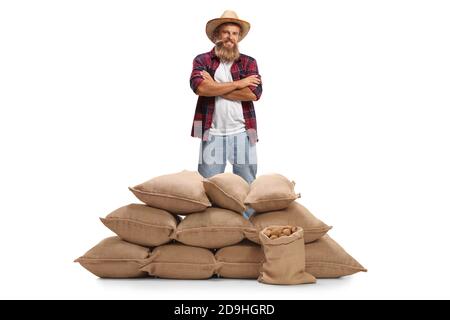 Joyeux fermier barbu posant avec des sacs avec des pommes de terre isolées dessus arrière-plan blanc Banque D'Images