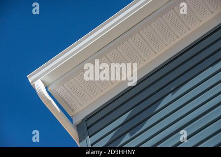 Système colonial de garde de gouttière blanche, fascia, bord de goutte, soffit fournissant la ventilation au grenier, avec le parement de bardeaux bleu pacifique maison de luxe Banque D'Images