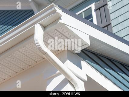 Système de garde de gouttière blanc colonial, fascia, bord d'égouttement, soffit fournissant la ventilation au grenier, avec le luxe de parement horizontal de vinyle bleu pacifique Banque D'Images