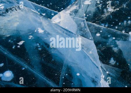 Winter Baikal, recouvert d'une couche épaisse de glace transparente avec des fissures et des bulles de méthane blanches congelées. Vue de dessus. Arrière-plan naturel. Copier l'espace. Banque D'Images