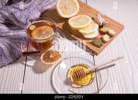 Réchauffer du thé vitaminé avec du citron et du gingembre dans une tasse de verre, fond blanc. Orientation horizontale. Banque D'Images